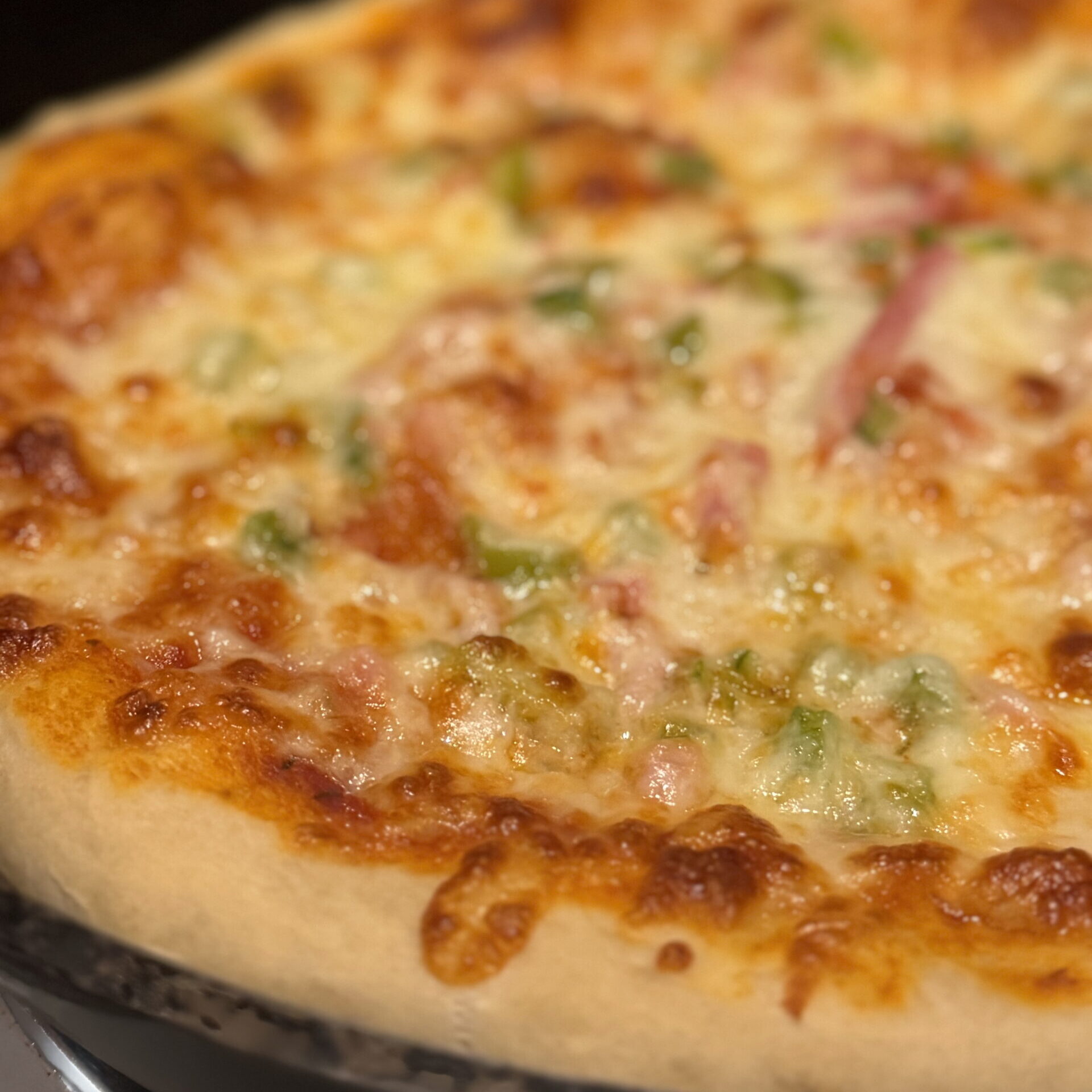 Best ever homemade cast iron pizza with bubbly cheese and golden crust